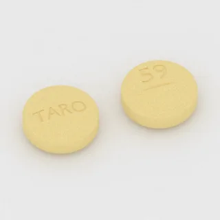 Amiodaron 400 mg Tablette: gelb, rund, 13 mm, mit Bruchkerbe, Prägung TARO auf der einen Seite und 59 auf der anderen.
