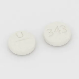 Baclofen 10 mg Tablette: weiß, rund, 8 mm, mit Bruchkerbe, Prägung U auf der einen Seite und 343 auf der anderen.