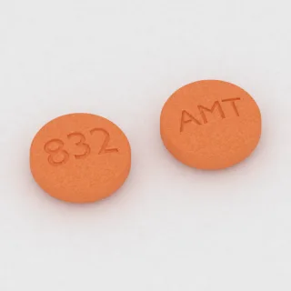 Amantadine 100 mg tablet: orange, round, 7 mm, imprinted 832 on one side and AMT on the other.