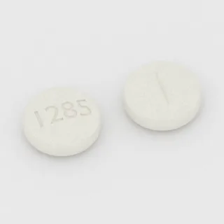 Baclofen 10 mg Tablette: weiß, rund, 8 mm, mit Bruchkerbe, Prägung 1285.