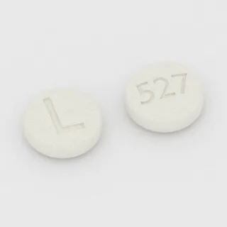 Clonazepam 2 mg Tablette: weiß, rund, 6 mm, Prägung L auf der einen Seite und 527 auf der anderen.