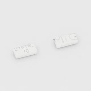 Cetirizin 10 mg Tablette: weiß, rechteckig, 9 mm, mit Bruchkerbe, Prägung ZYRTEC 10 MG.
