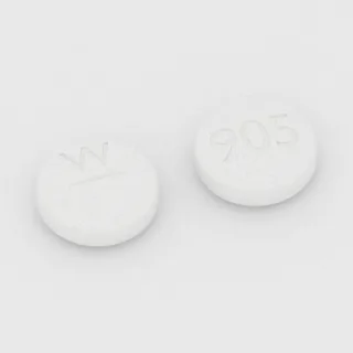 Captopril 100 mg Tablette: weiß, rund, 11 mm, mit Bruchkerbe, Prägung W auf der einen Seite und 905 auf der anderen.